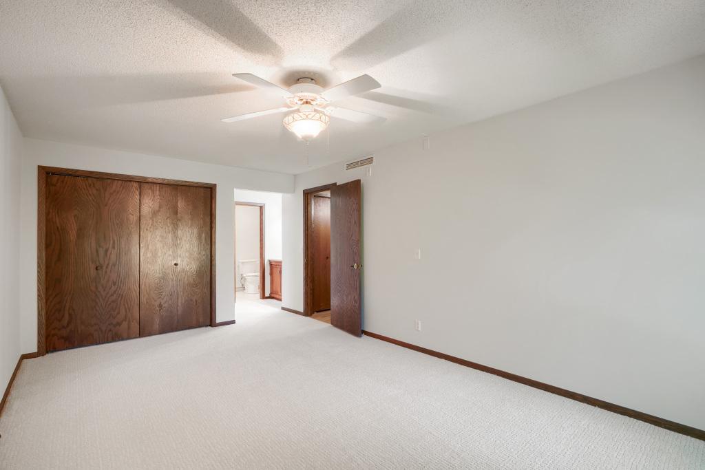 Primary bedroom with views into vanity and bathroom area