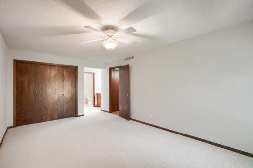 Primary bedroom with views into vanity and bathroom area