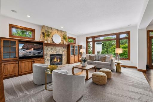 Sophisticated comfort meets timeless design. Soaring windows, rich custom millwork, and a striking natural-stone fireplace create an inviting great room designed for refined entertaining and effortless everyday living. A truly elevated retreat.