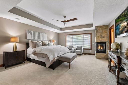A private retreat designed for refined living. The spacious primary suite pairs a striking stone fireplace with elegant finishes, generous natural light, and a serene sitting area—creating a luxurious sanctuary to unwind, recharge, and escape.