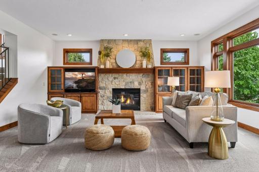 Gather in a breathtaking great room anchored by a floor-to-ceiling stone fireplace, custom built-ins, and expansive windows framing serene views. A warm, sophisticated space designed for both grand entertaining and everyday living.
