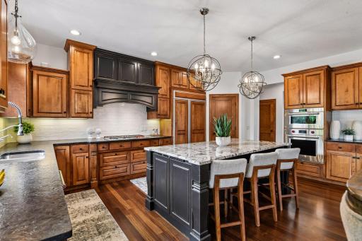 Designed for the culinary enthusiast, this exceptional chef's kitchen features custom cabinetry, premium appliances, rich hardwood floors, w/ striking granite island. An elegant blend of craftsmanship, style, & functionality 4 effortless entertaining