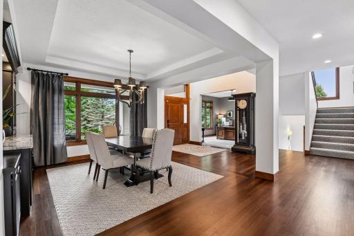 Gracious formal dining room designed 4 elegant entertaining, featuring rich walnut stained hardwood floors, sophisticated architectural details, and abundant natural light. The perfect setting for hosting intimate dinner parties, holiday gatherings.
