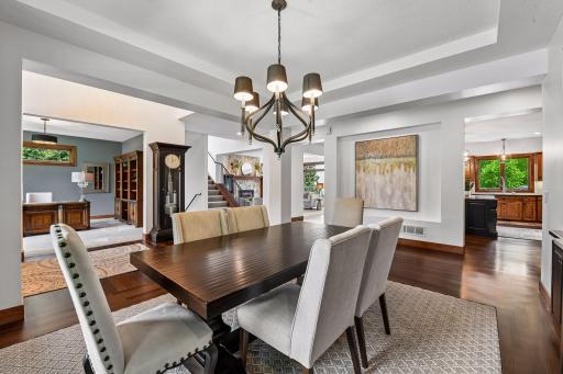 Sophisticated and inviting, this formal dining room offers the perfect setting for elevated entertaining. Rich hardwood floors, architectural ceiling detail, and seamless flow to the home's gathering spaces create an atmosphere of timeless elegance.