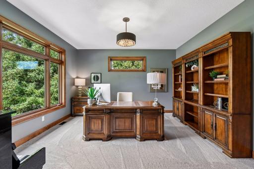 A distinguished executive office designed for productivity and sophistication. The perfect work-from-home retreat blending privacy, comfort, and abundant natural light with serene views.