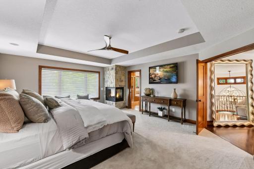 Retreat to a luxurious owner's suite featuring a dramatic tray ceiling, cozy fireplace, and generous proportions designed for comfort and sophistication. A true private sanctuary offering warmth, elegance, and the perfect escape at day's end.