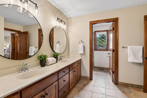 Designed for both luxury and convenience, this pass-through bath adjoins two spacious bedrooms and features dual vanities, a private water closet, and a separate tile-surround shower. Thoughtful design and quality finishes create an ideal retreat.
