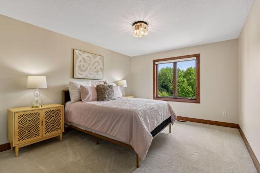 Inviting secondary bedroom featuring abundant natural light, plush carpeting, and peaceful views of backyard. This fourth upper bedroom is connected to a convenient pass-through full bath.