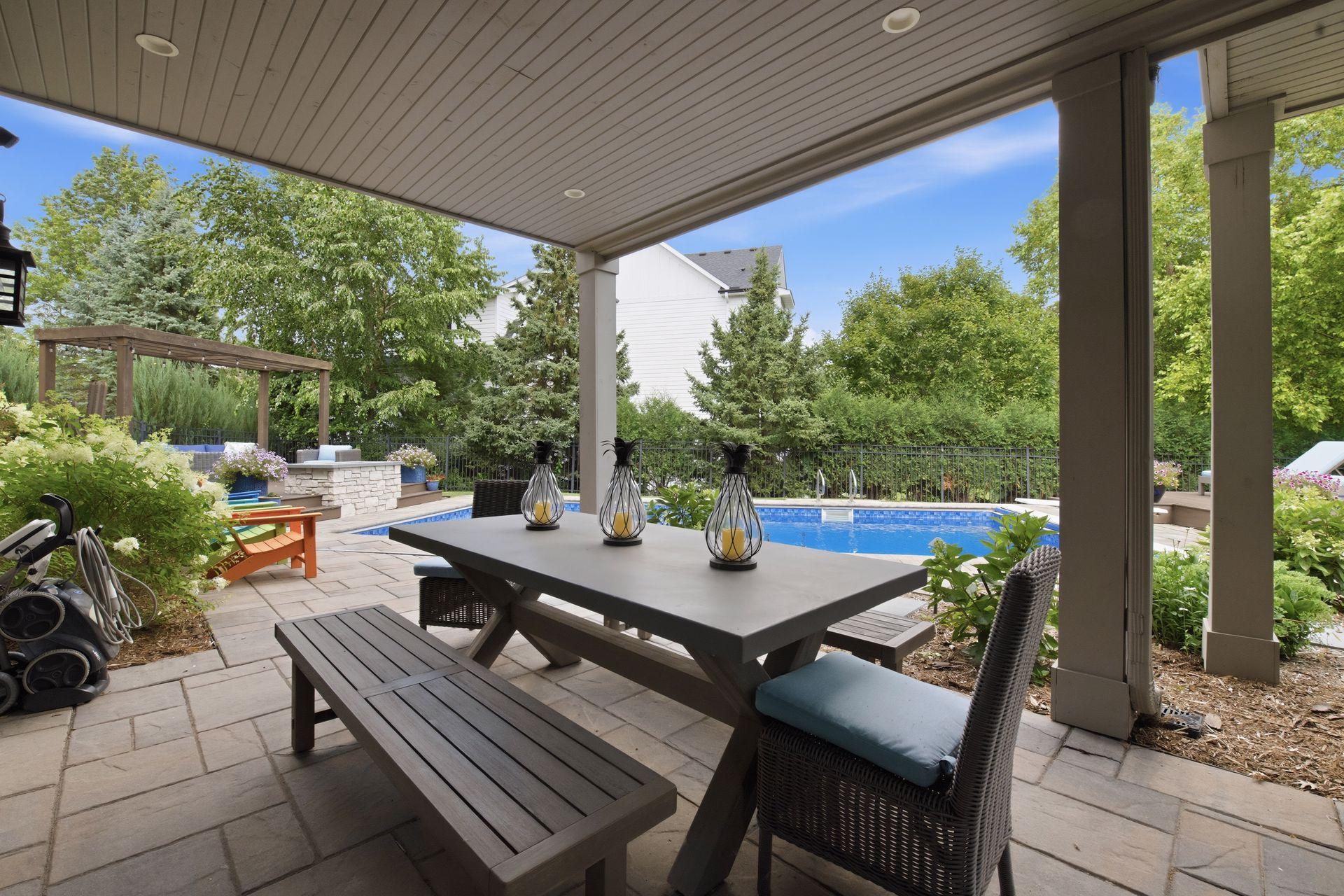 Picture yourself as you step into your backyard oasis from the lower level and enjoy a stunning outdoor retreat with a covered patio, lush landscaping, inviting pool, stonework and multiple spaces for relaxing and entertaining.