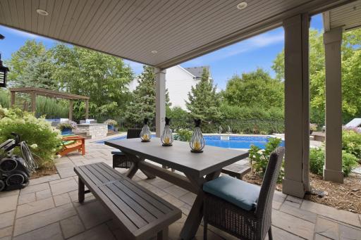 Picture yourself as you step into your backyard oasis from the lower level and enjoy a stunning outdoor retreat with a covered patio, lush landscaping, inviting pool, stonework and multiple spaces for relaxing and entertaining.