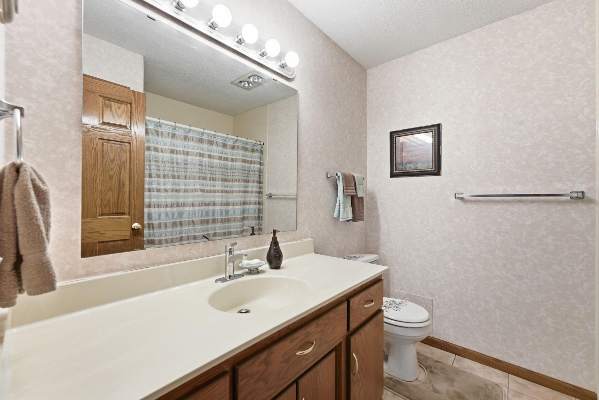 Full, private primary bathroom with a large vanity.
