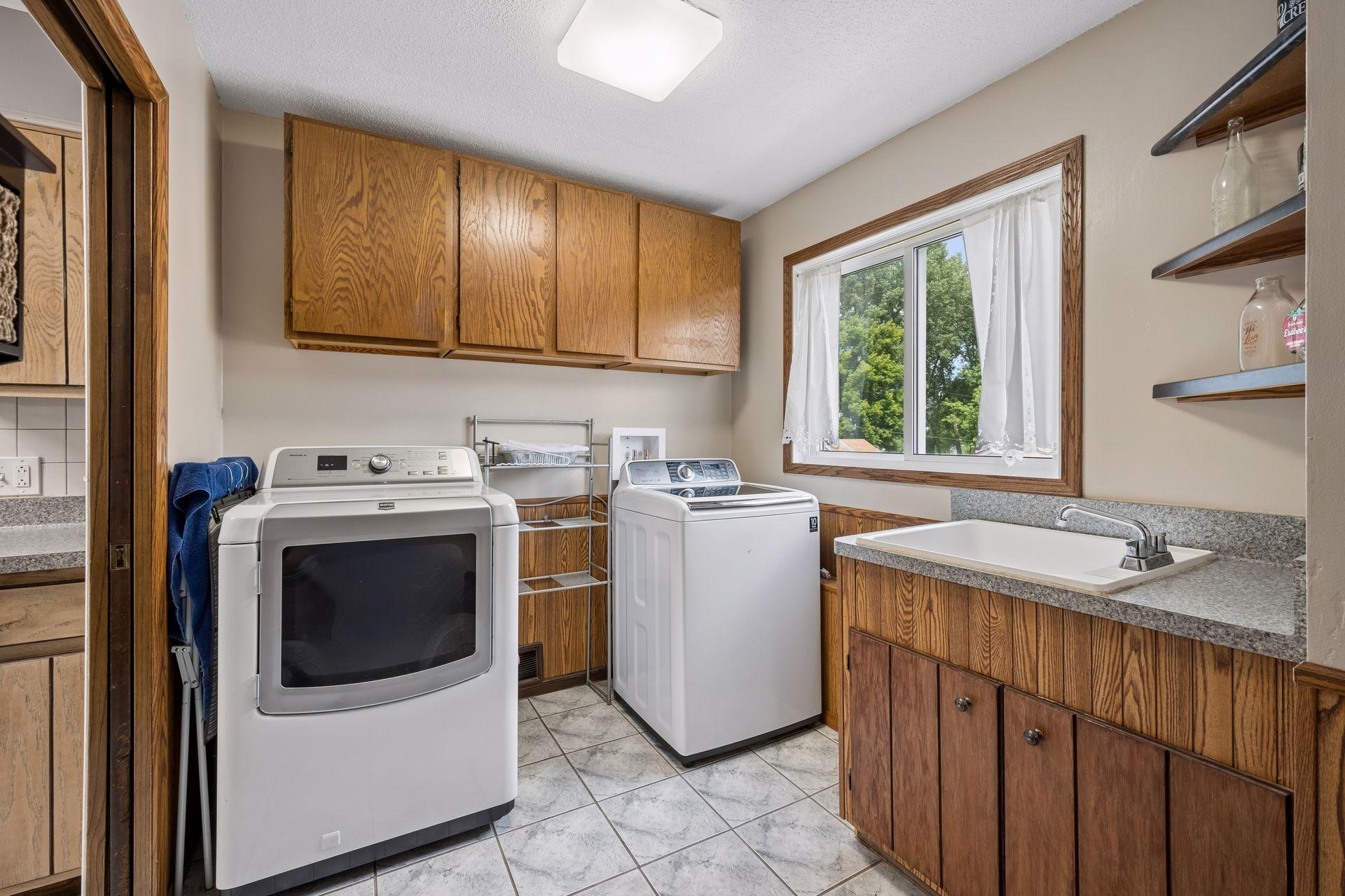 Convenient main level laundry with lots of storage and laundry sink.
