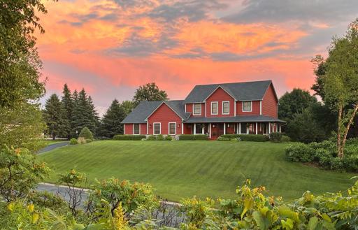 Gorgeous view of home & setting from across the street. Notice the wrap-around porch on the right & garage on the left side.