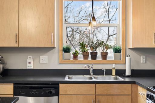 Window over the sink brings in natural light and highlights the kitchen’s clean finishes.