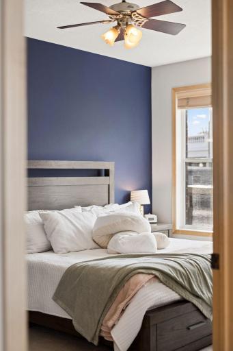 View into the spacious primary bedroom with great natural light and a calming accent wall.