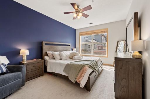 Large primary bedroom with expansive windows, soft natural light, and plenty of space for furnishings.