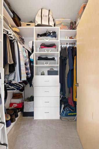 Walk-in closet with custom organization, shelving, and generous storage space.