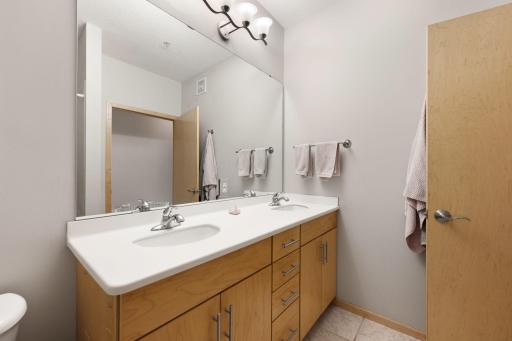 Primary bath with double vanity, abundant cabinet storage, and a clean modern design.