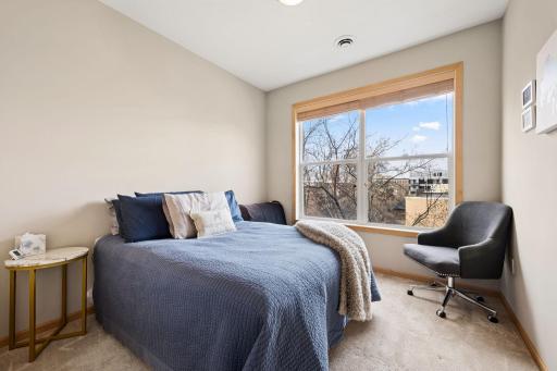 Bright secondary bedroom with large window, soft natural light, and flexible use.