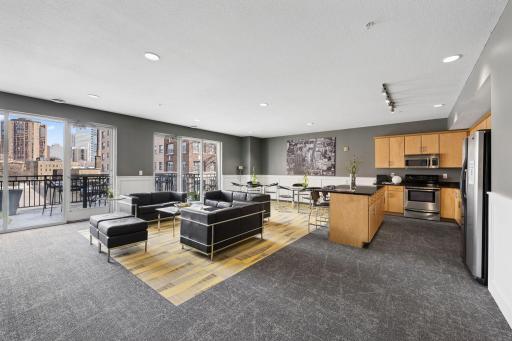 Stylish community room with lounge seating, kitchen area, and space for gatherings.