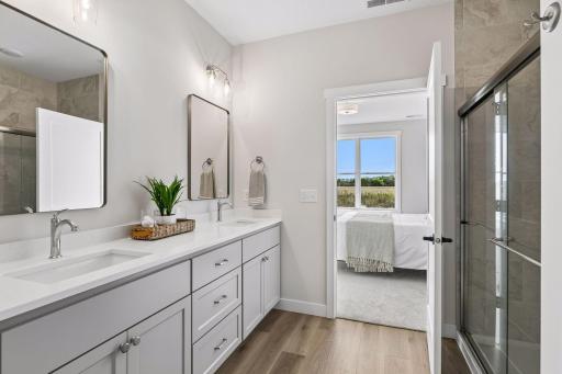 Private primary bathroom featuring dual luxurious tile shower