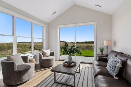 Walls of windows engulf the sunroom in natural light