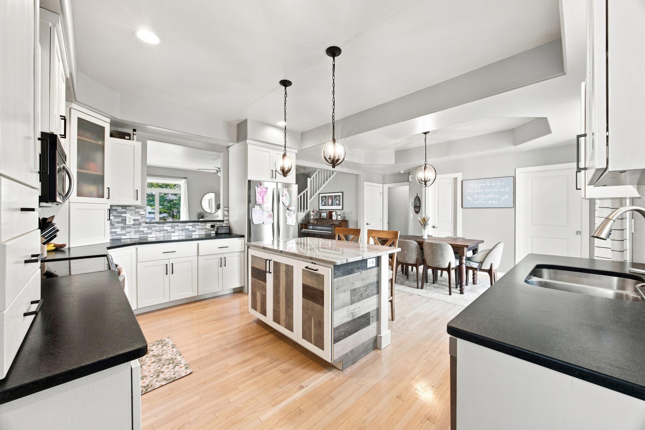 Kitchen with center island, granite countertops, ss appliances, lots of cabinets! Open area to living area above countertop.