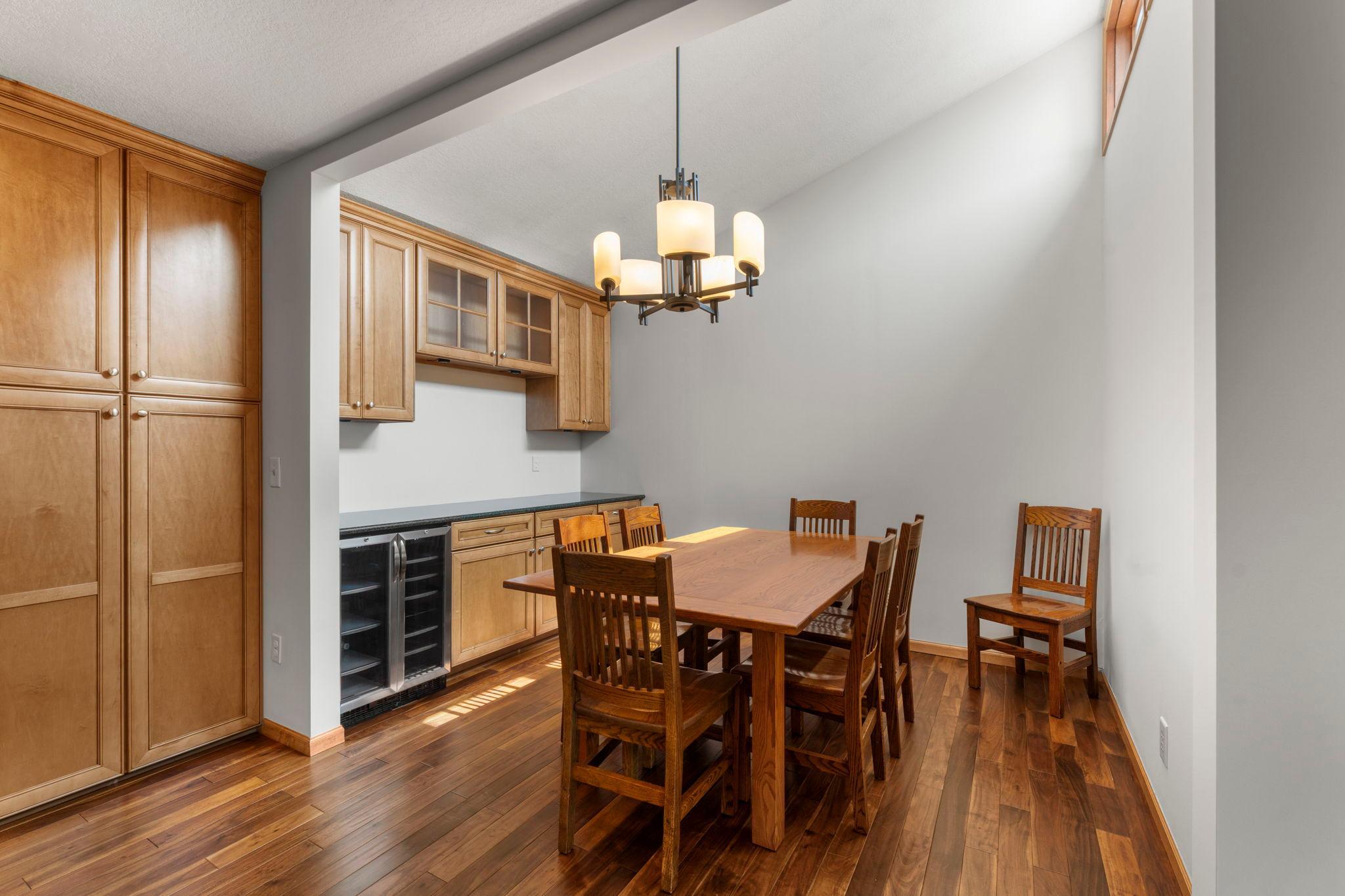 A built-in buffet counter with a beverage fridge and glass-front cabinetry provides the perfect spot for serving, entertaining, or displaying decorative pieces.