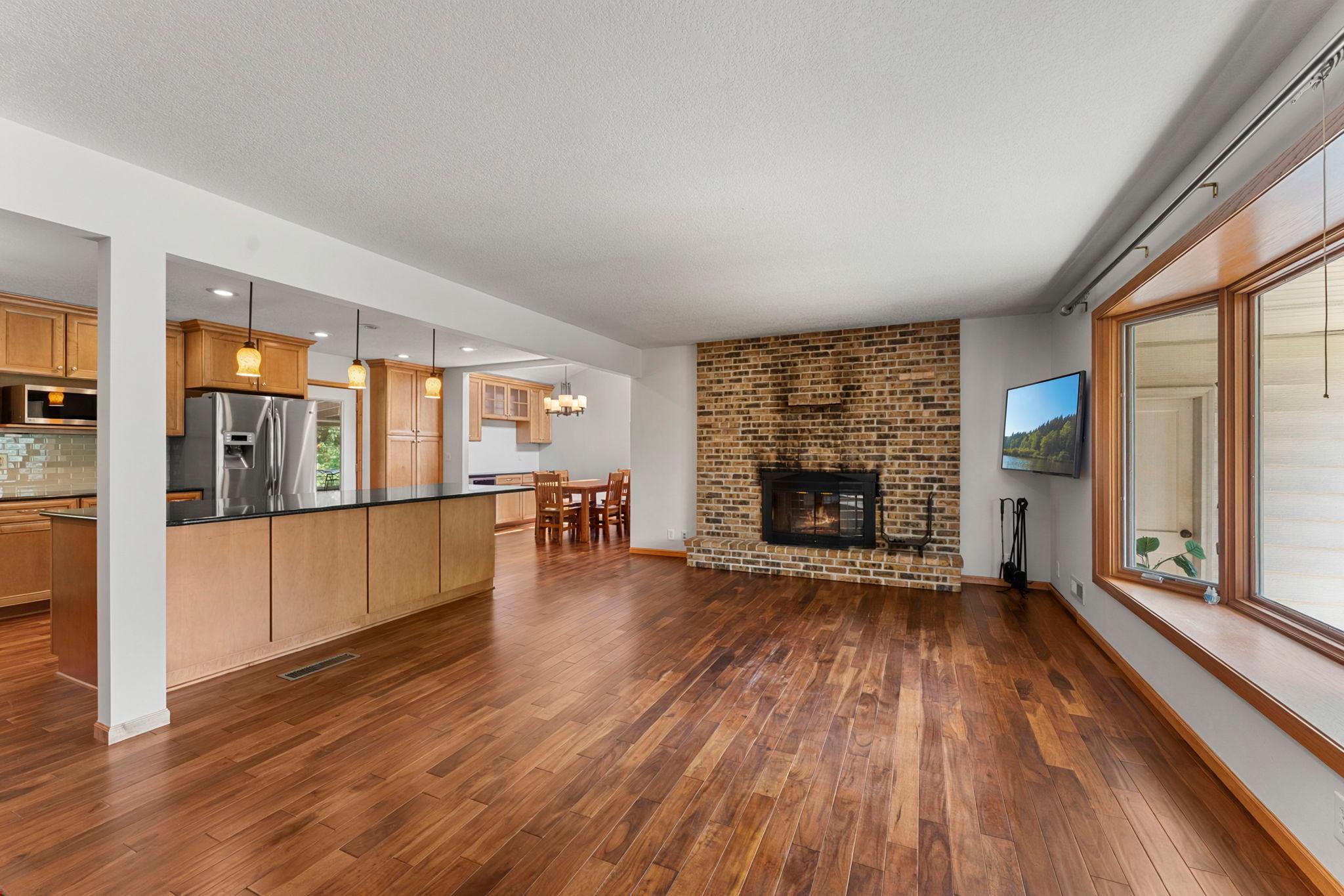 A wood-burning fireplace framed by an original brick surround brings warmth and character to the space.
