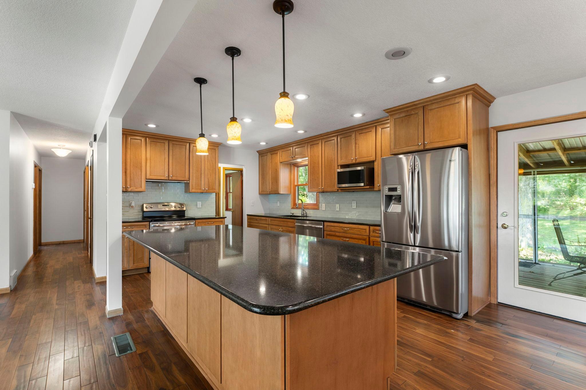 Stainless steel appliances, tile backsplash, soft-close cabinetry, and under-cabinet lighting.