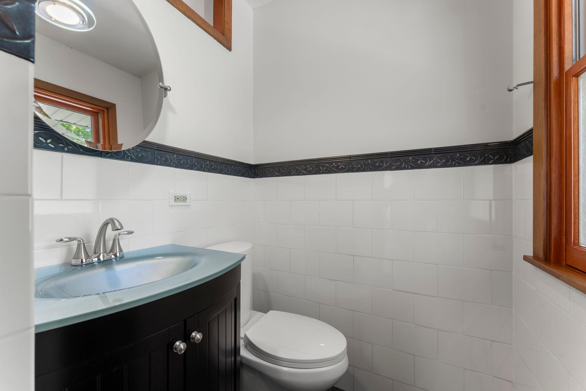 Two main-level bathrooms add everyday convenience, including a 1/2 bathroom with tile detailing.