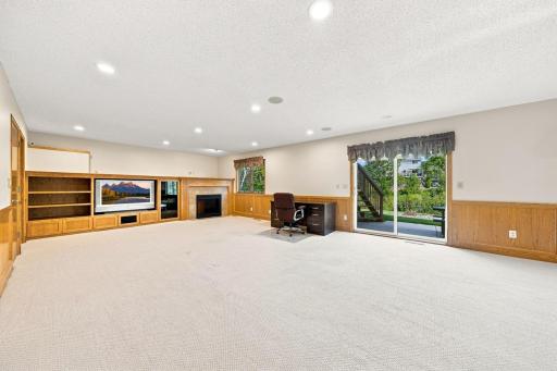 large rec room with buidins and gas fire plce