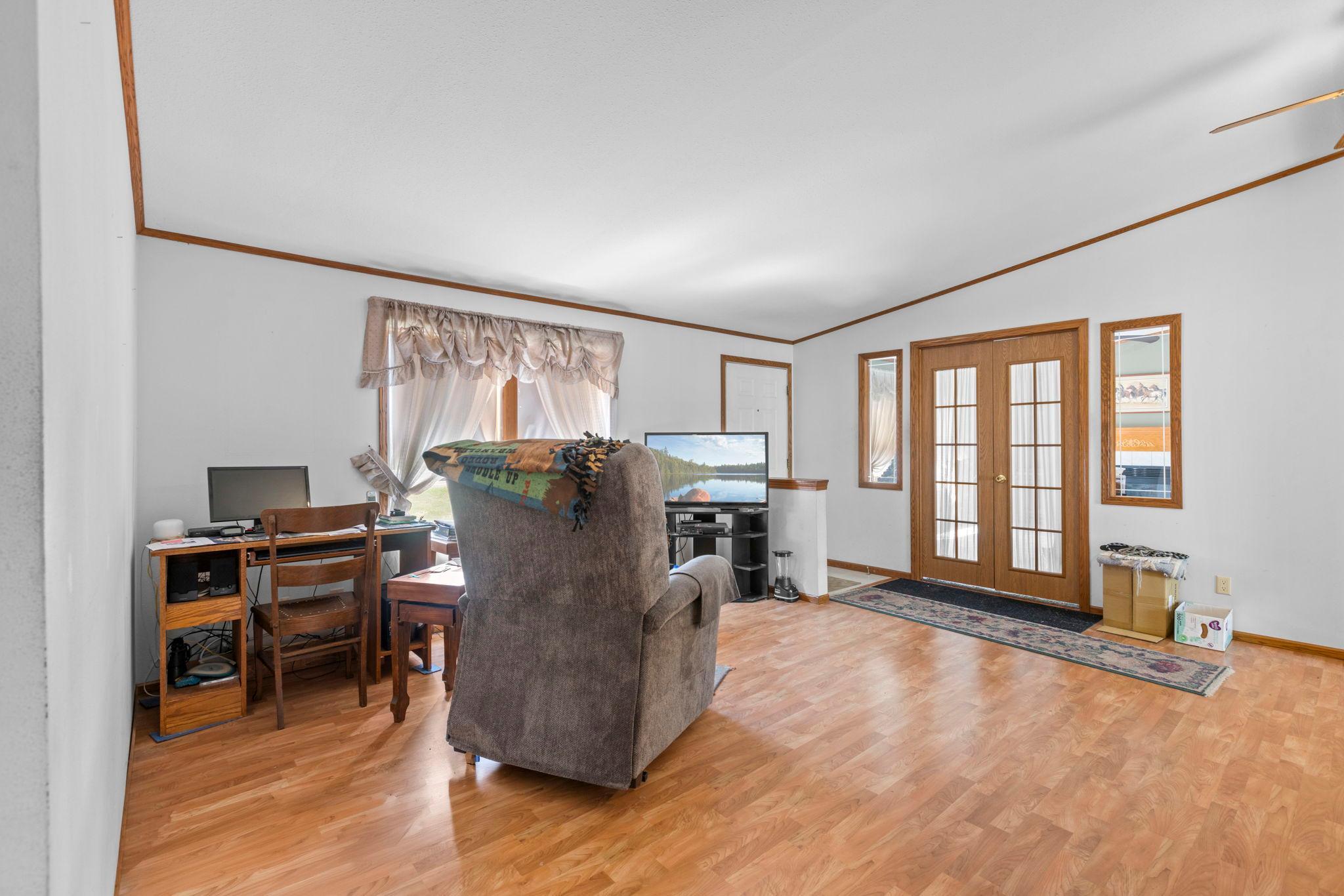The living room located just inside the front entry is a great additional living space with double doors to the family room