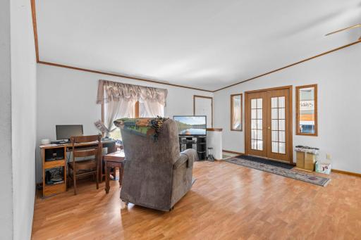 The living room located just inside the front entry is a great additional living space with double doors to the family room