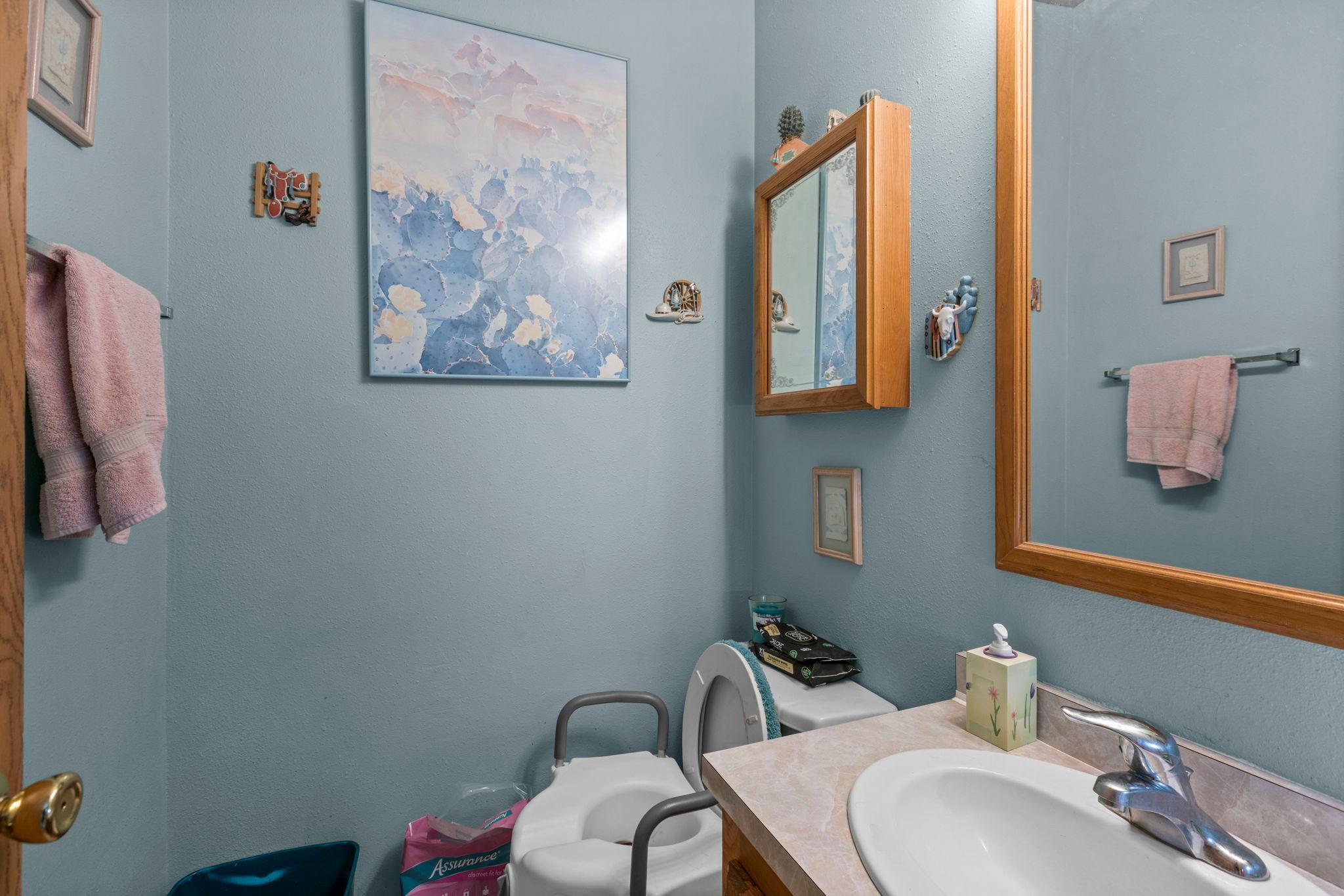 The half bath is located in the hallway off the kitchen, ideal for guests