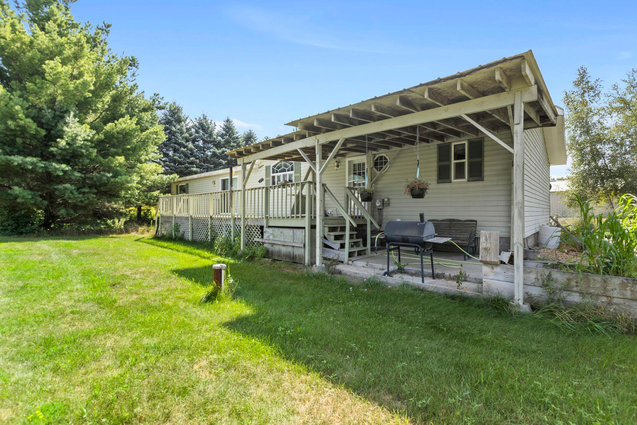 The backside of the home has a spacious deck, partially covered, great for grilling & enjoying the outdoors in rainy weather