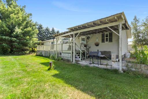 The backside of the home has a spacious deck, partially covered, great for grilling & enjoying the outdoors in rainy weather