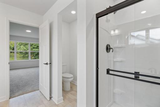 Dual sinks, a glass-enclosed shower and a separate soaking tub contribute to the spa-like atmosphere of the en-suite bathroom