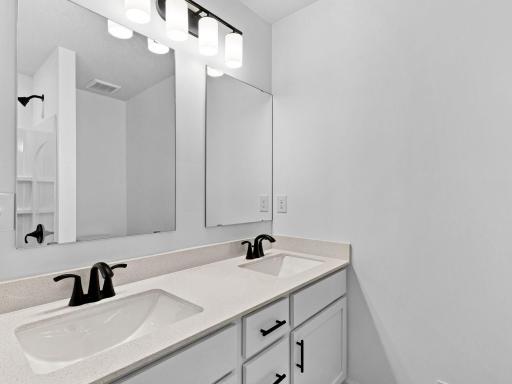 This shared full bathroom includes a full-width vanity mirror and a shower-tub combination.