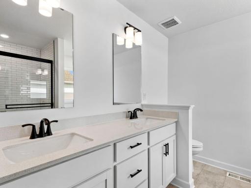 Dual sinks, a glass-enclosed shower and separate soaking tub are included in the en-suite bathroom