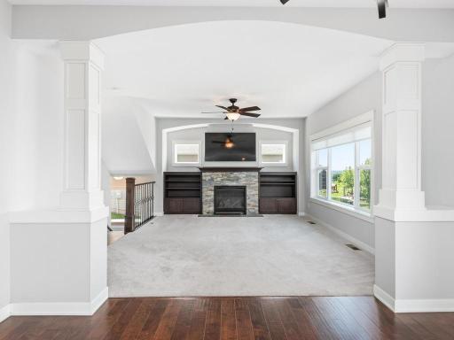 Grand entrance to the living room showcasing beautiful archways, rich hardwood flooring, vaulted ceilings, and seamless flow throughout the main level.