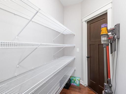 Generous walk-in pantry with custom shelving systems provides abundant storage space for all your household needs.