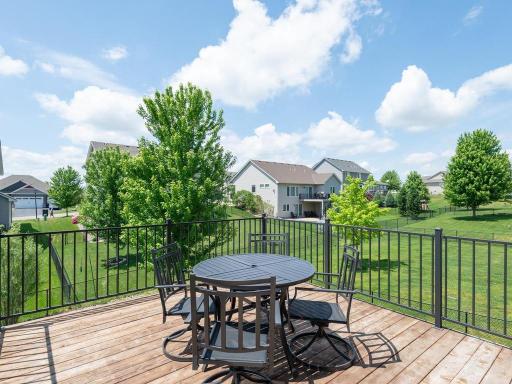 Enjoy outdoor living on this spacious deck with aluminum railing, overlooking the large fenced backyard, perfect for entertaining and relaxation.