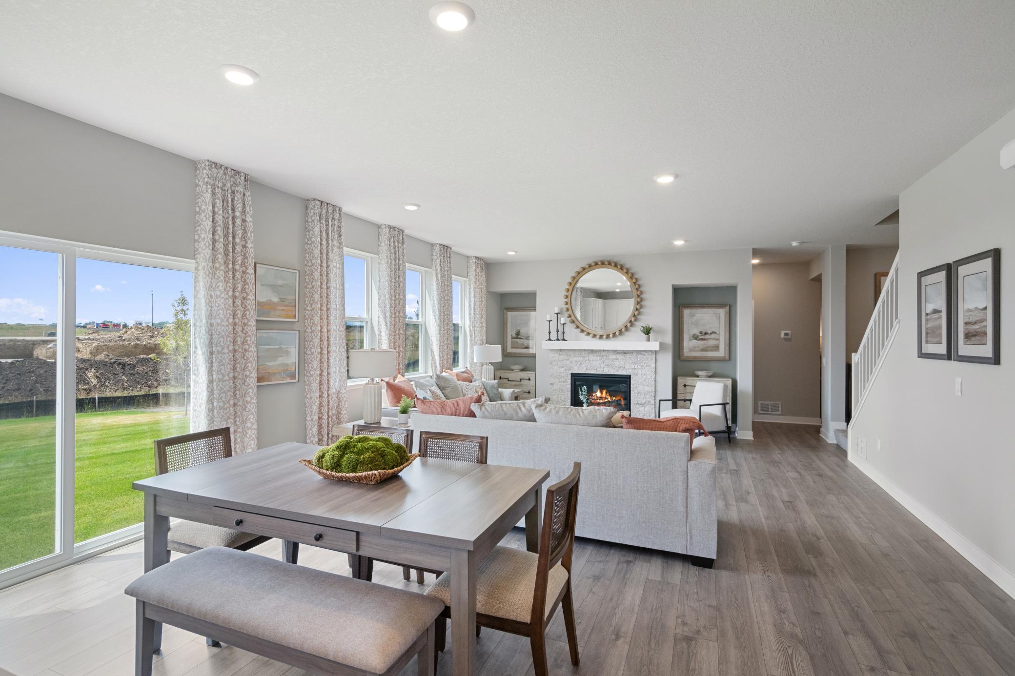 Wonderful open concept that flows from kitchen to living room. The luxury vinyl plank flooring extends into the living room and this home will have the stone surround at the fireplace. Photo of model home, colors and finishes may vary.