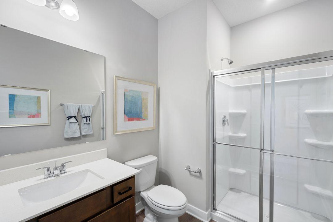 Main level bathroom with a walk-in shower. Photo of model home, colors and finishes may vary.