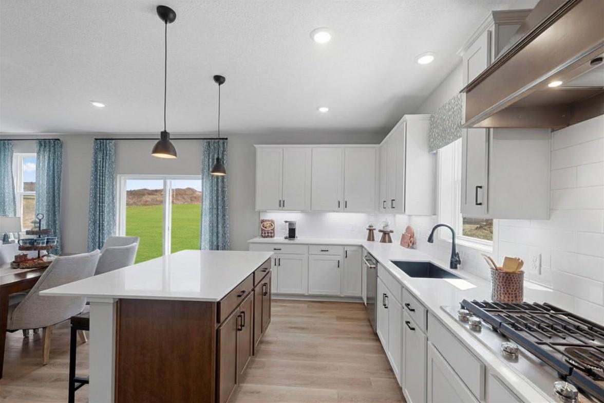 There is ample counter and cabinet space in this kitchen. The family chef will appreciate the prep space and the 5-burner cooktop. Photo of model home, colors and finishes may vary.