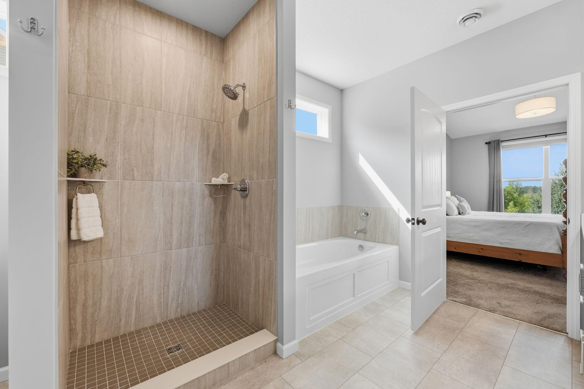 Primary bath with tile walk in shower and separate soaking tub