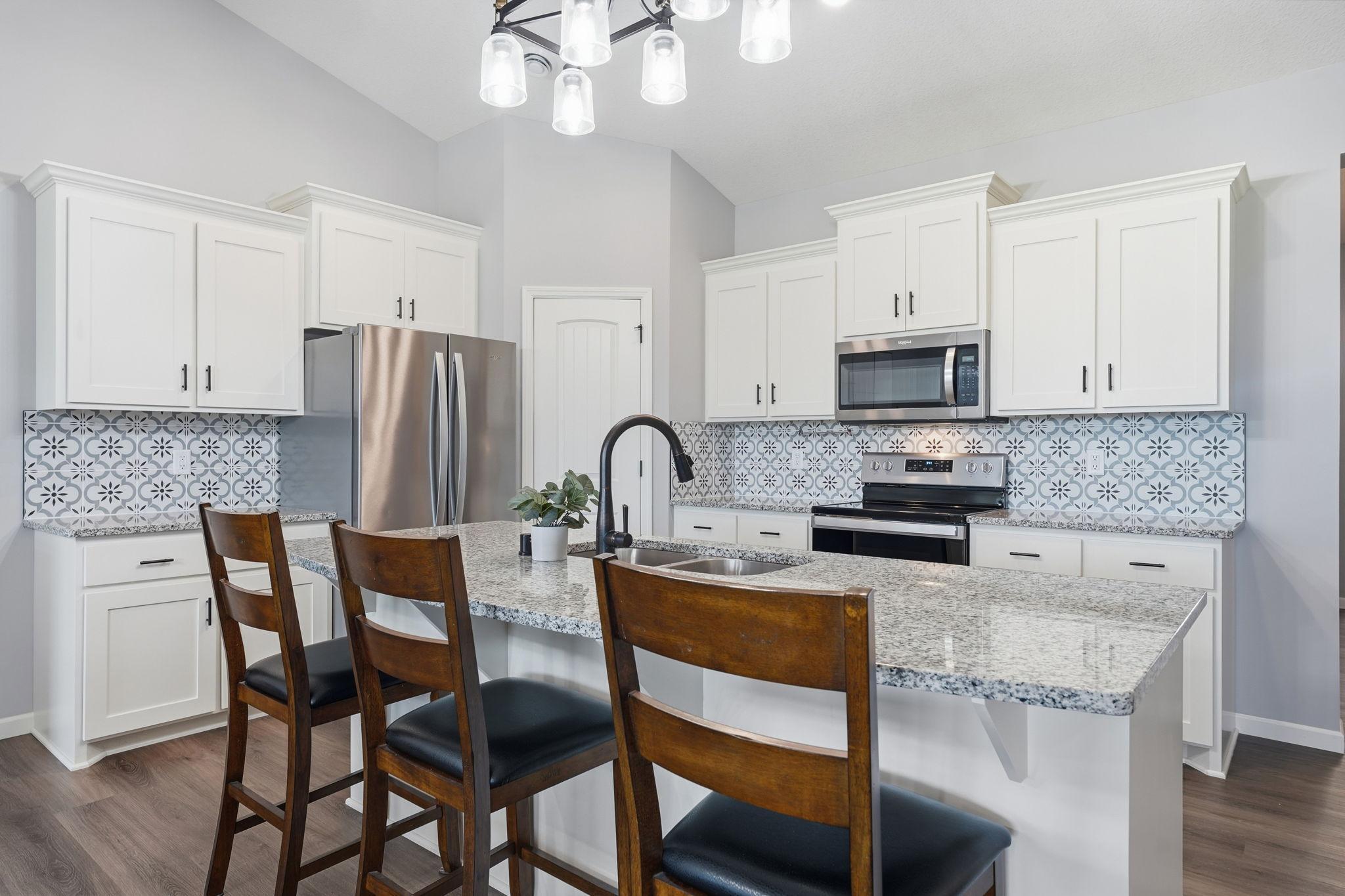Beautiful and bright kitchen with pantry, custom backsplash, and plenty of storage.