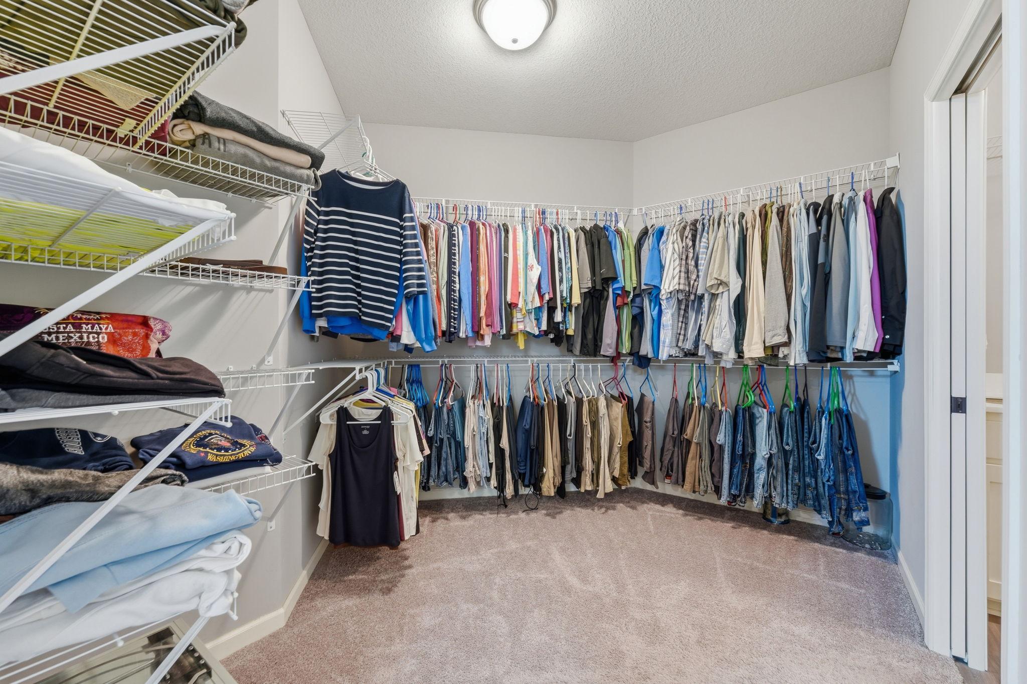 Large walk in primary closet attached to both primary bath and laundry