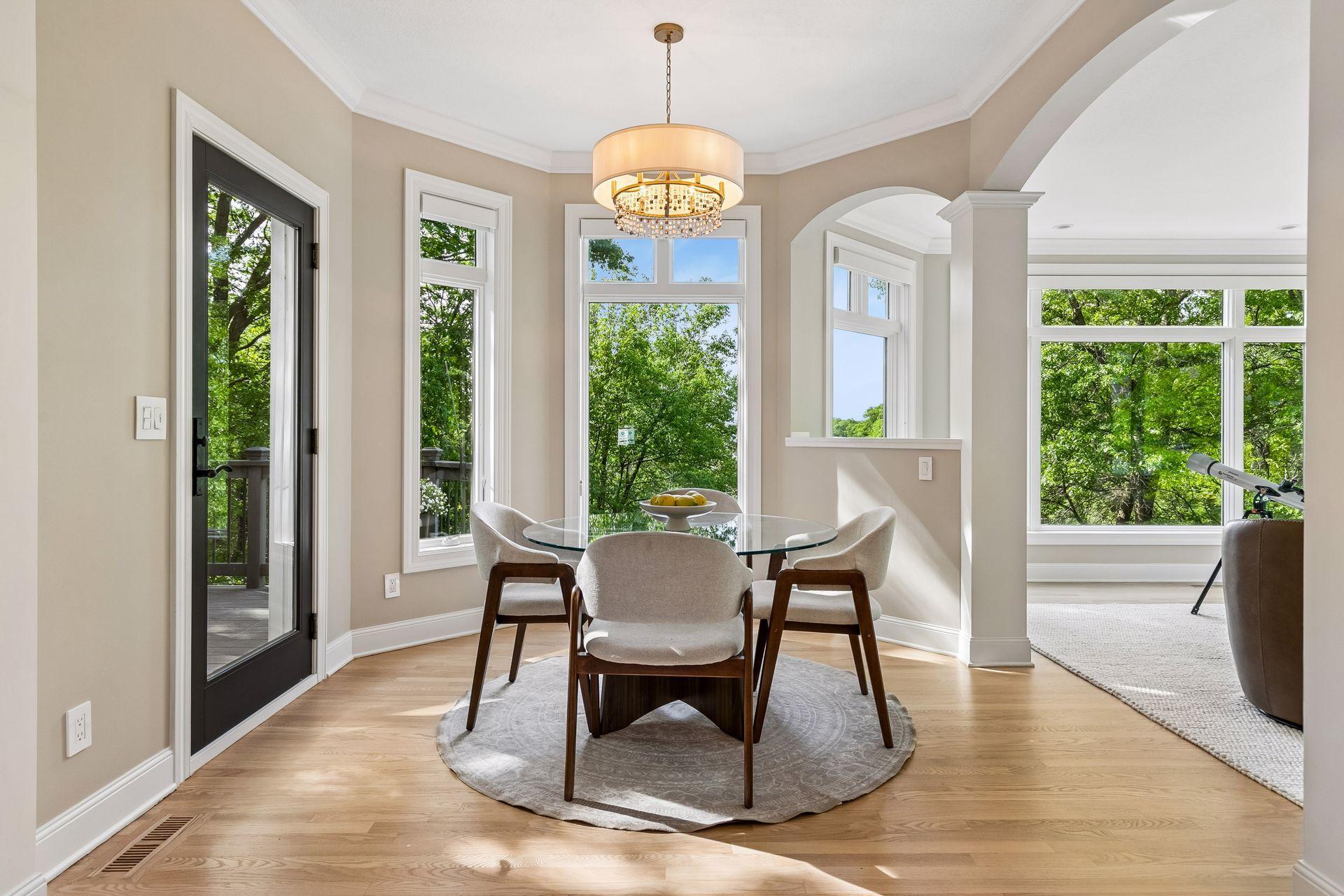 Lovely dinette surrounded by windows, offering beautiful natural light and picturesque lake views.